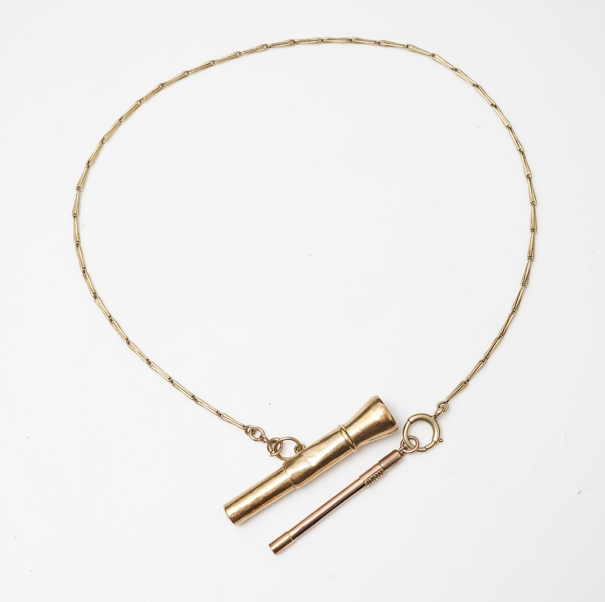 A gold chain, cigar piercer and toothpick, the chain of fancy linking, length approximately 36.5cm, stamped 14K, suspending a toothpick, length 5cm, stamped 9ct, and a cigar piercer, stamped 585, combined gross weight ap